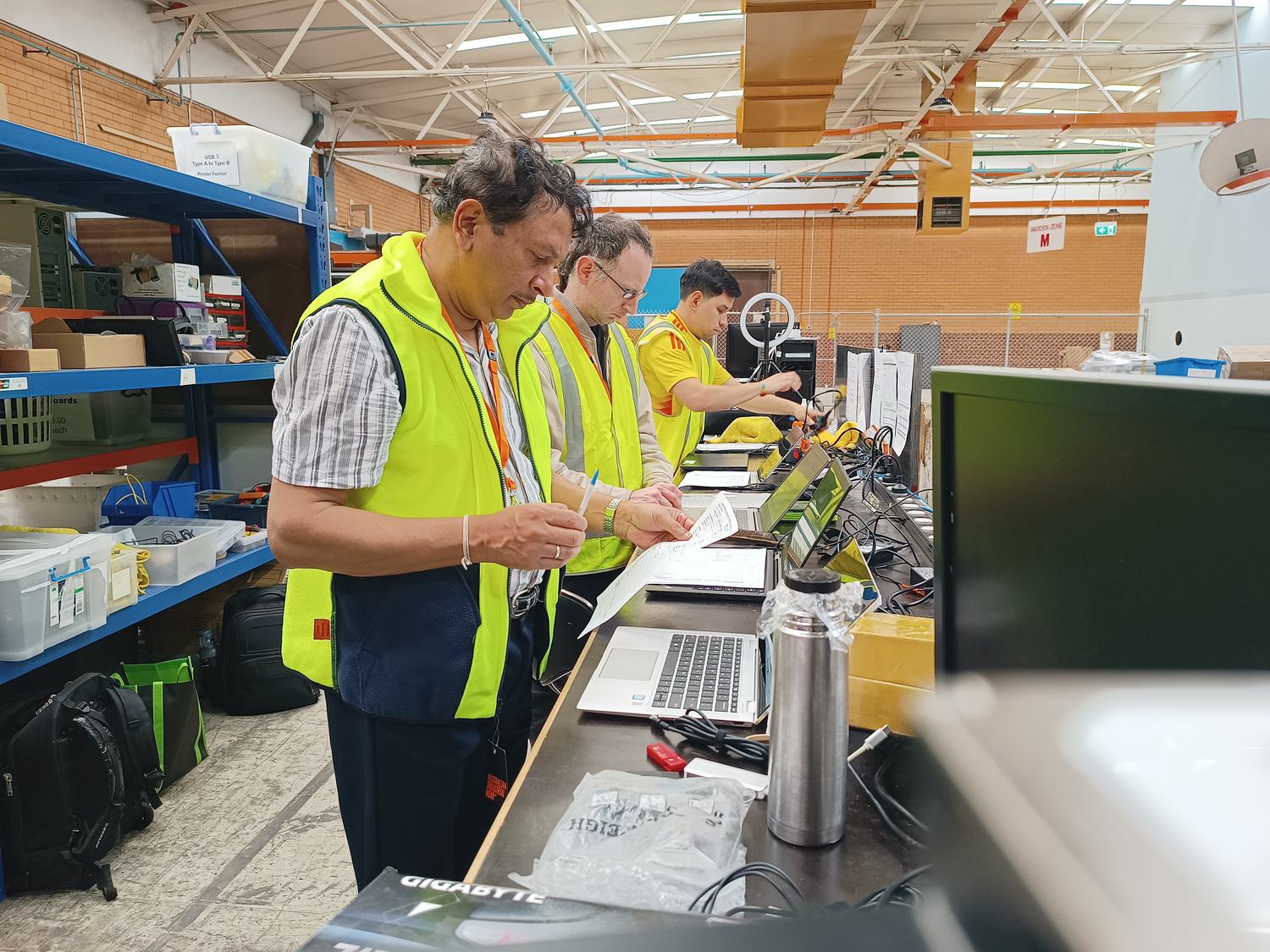 Volunteers checking over refurbished laptops in the build room